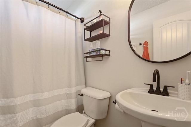 bathroom with a sink, toilet, and a shower with curtain