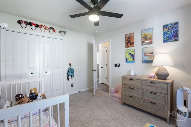 bedroom with light colored carpet, a closet, ceiling fan, and baseboards