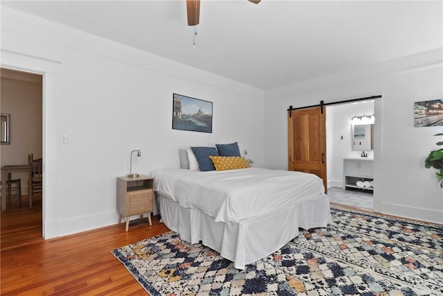 1216 E 31st St, Savannah, GA 31404 - bedroom with wood finished floors, baseboards, a barn door, ensuite bathroom, and ceiling fan