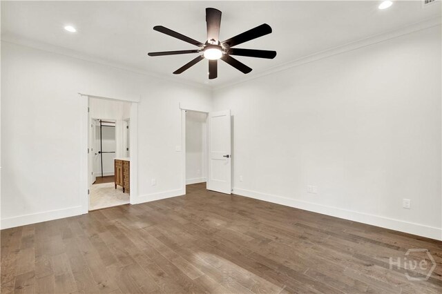 unfurnished bedroom with crown molding, dark wood-style floors, baseboards, recessed lighting, and connected bathroom