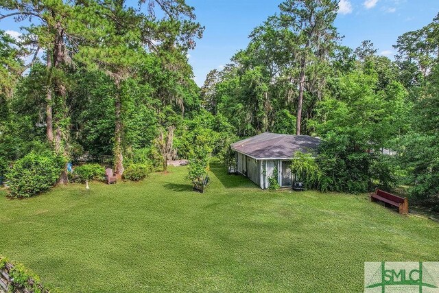 156 Lansing St, Brunswick, GA 31525 - view of green lawn with an outbuilding and a wooded view