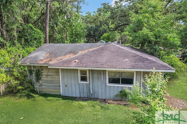156 Lansing St, Brunswick, GA 31525 - view of home's exterior with a yard, a shingled roof, and board and batten siding