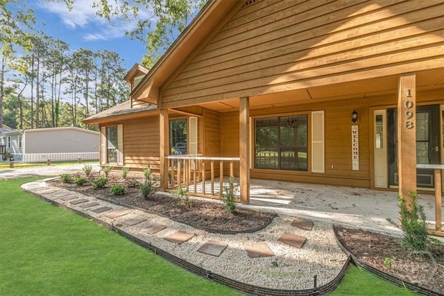 back of house with a porch and a lawn