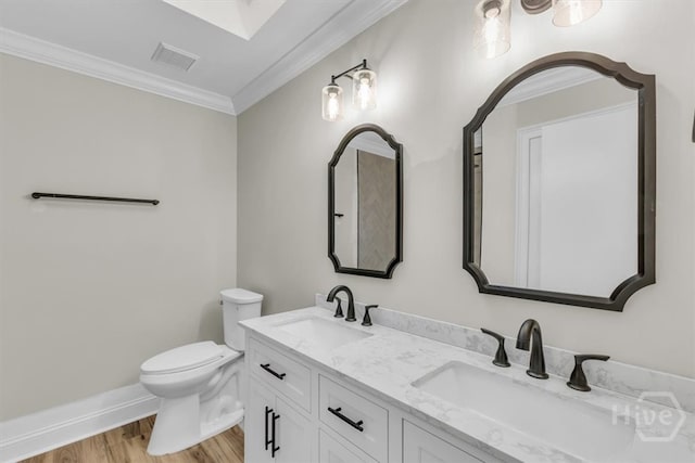 full bathroom with wood finished floors, toilet, crown molding, double vanity, and baseboards