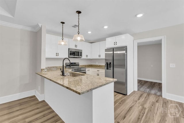 kitchen featuring stainless steel appliances, light wood-type flooring, a sink, baseboards, and recessed lighting