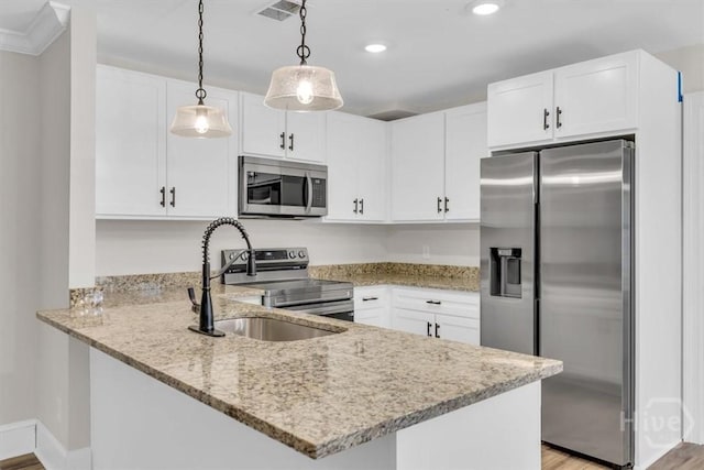 kitchen featuring stainless steel appliances, a peninsula, light stone countertops, a sink, and white cabinets