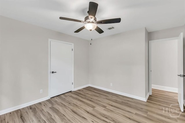 spare room with ceiling fan, wood finished floors, and baseboards