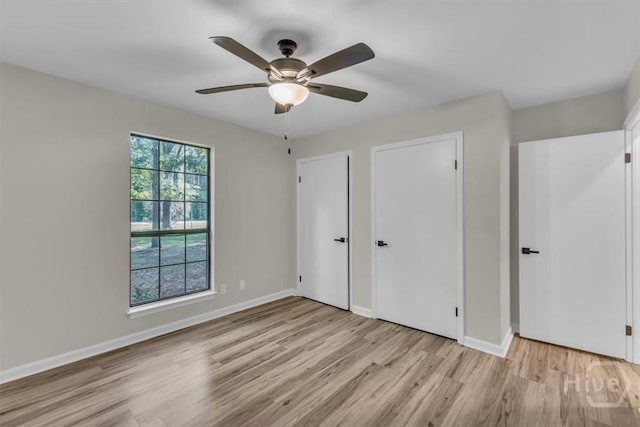 unfurnished bedroom with wood finished floors, baseboards, and ceiling fan