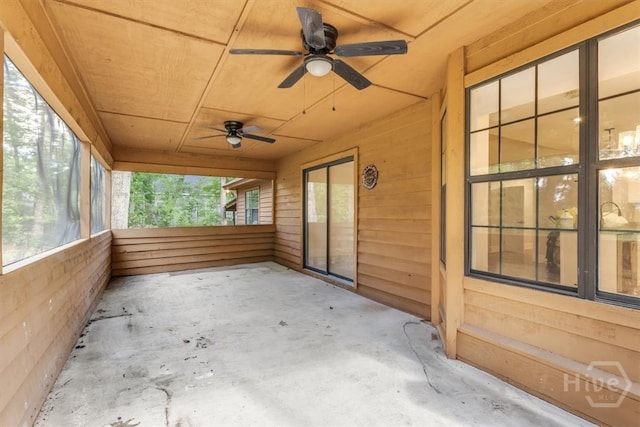 unfurnished sunroom with ceiling fan