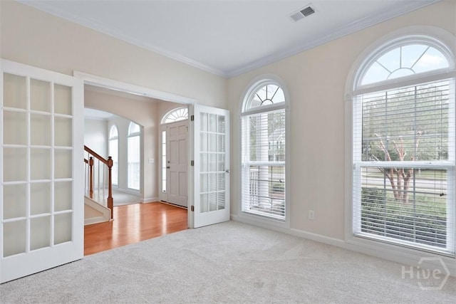 119 Sutton Ln, Pooler, GA 31322 - foyer with carpet floors, ornamental molding, arched walkways, stairway, and french doors