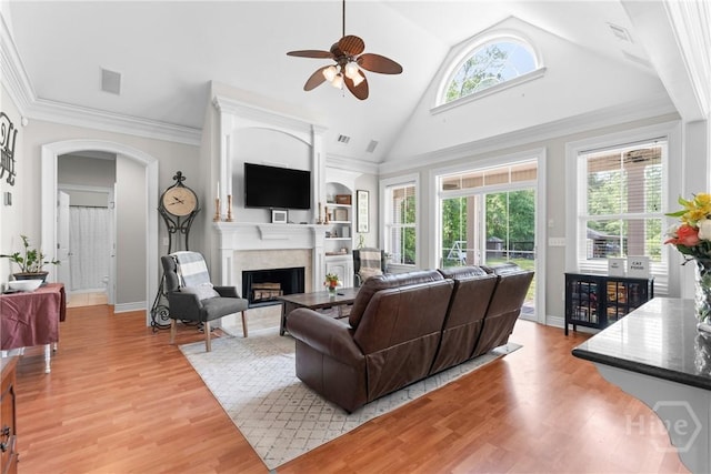 784 Ebenezer Rd, Rincon, GA 31326 - living room featuring arched walkways, ceiling fan, a fireplace, light wood-type flooring, and high vaulted ceiling