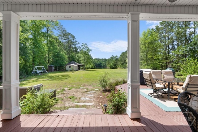 784 Ebenezer Rd, Rincon, GA 31326 - wooden deck featuring a lawn, outdoor dining area, and an outbuilding