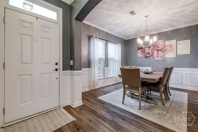 417 Keiffer Dr, Rincon, GA 31326 - dining room featuring a chandelier, dark wood-type flooring, crown molding, arched walkways, and wainscoting