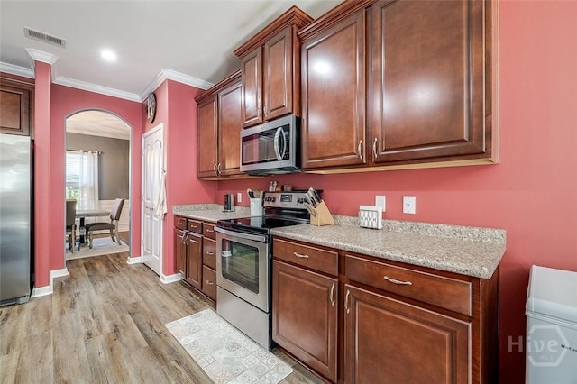 417 Keiffer Dr, Rincon, GA 31326 - kitchen featuring stainless steel appliances, arched walkways, light wood-style floors, ornamental molding, and baseboards