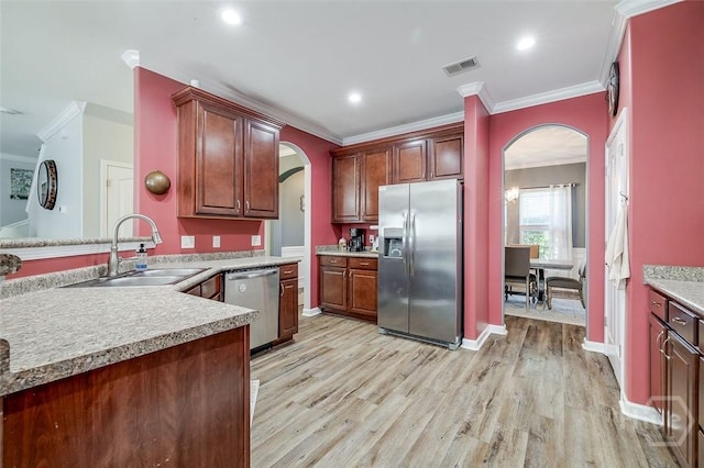 417 Keiffer Dr, Rincon, GA 31326 - kitchen with appliances with stainless steel finishes, arched walkways, a sink, crown molding, and light wood-style flooring