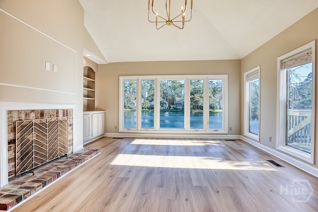 3 Riding Ln, Savannah, GA 31411 - unfurnished living room featuring a chandelier, built in shelves, wood finished floors, baseboards, and high vaulted ceiling