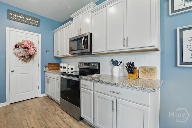 203 Merganser Dr, Pooler, GA 31322 - kitchen featuring appliances with stainless steel finishes, tasteful backsplash, light wood finished floors, light stone counters, and white cabinetry