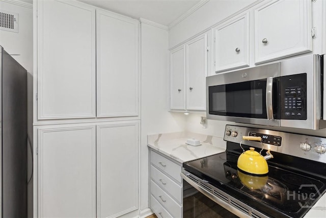 5633 Lafitte Dr, Savannah, GA 31406 - kitchen featuring stainless steel appliances, white cabinetry, ornamental molding, and light stone countertops