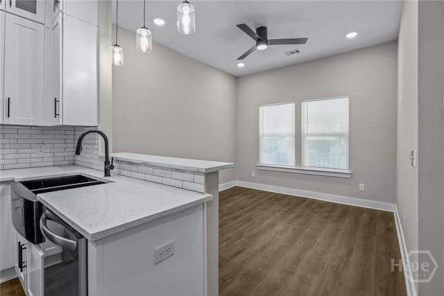 17 Nelson St, Savannah, GA 31415 - kitchen with ceiling fan, a peninsula, decorative backsplash, light stone countertops, and white cabinetry