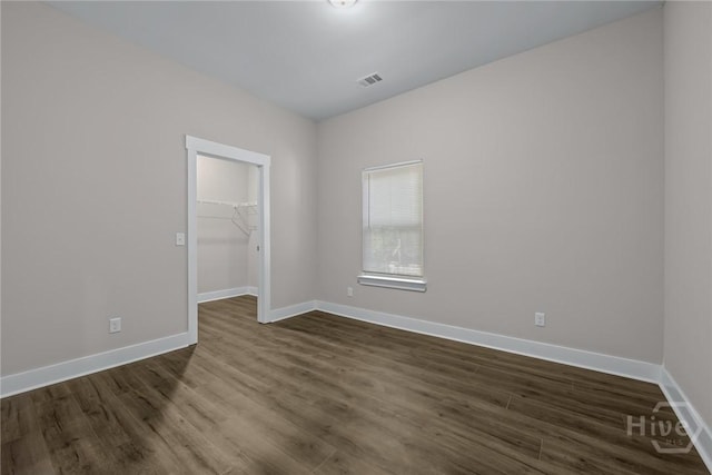 17 Nelson St, Savannah, GA 31415 - unfurnished bedroom featuring dark wood-style flooring, a spacious closet, baseboards, and a closet