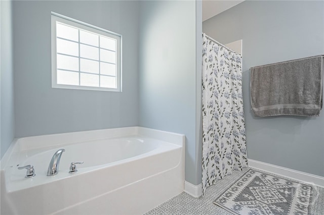bathroom featuring a bath, a shower with curtain, and baseboards