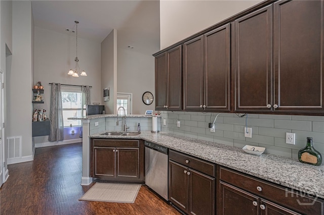 kitchen with dishwasher, a towering ceiling, a sink, a peninsula, and dark wood-style floors
