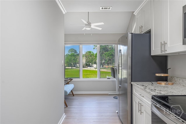 3005 River Dr Unit 209B, Savannah, GA 31404 - kitchen featuring ceiling fan, light wood finished floors, white cabinets, baseboards, and light stone counters