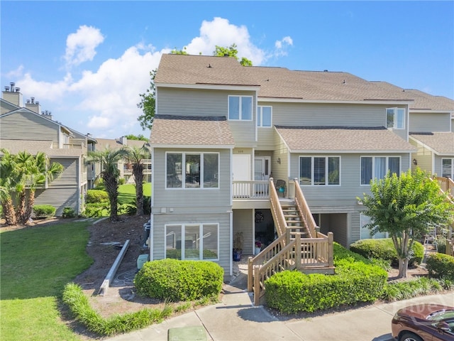 3005 River Dr Unit 209B, Savannah, GA 31404 - rear view of house featuring stairway, a deck, roof with shingles, a yard, and a residential view