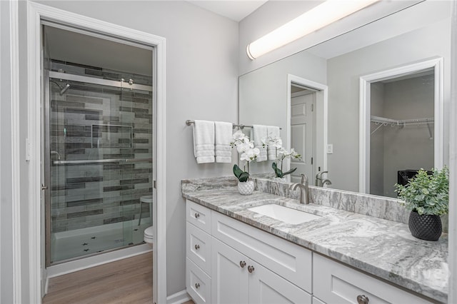 3005 River Dr Unit 209B, Savannah, GA 31404 - full bathroom featuring a stall shower, toilet, vanity, wood finished floors, and baseboards