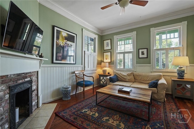 542 E Gaston St Unit A, Savannah, GA 31401 - living area featuring wainscoting, ceiling fan, wood-type flooring, a tile fireplace, and crown molding