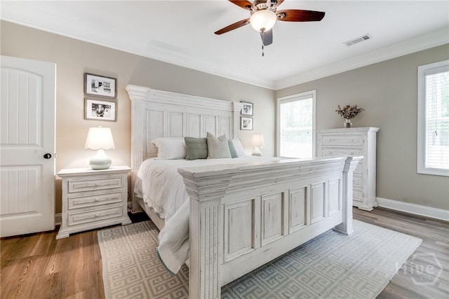 bedroom with ornamental molding, wood finished floors, baseboards, and ceiling fan