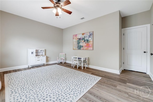 spare room featuring wood finished floors, a ceiling fan, and baseboards