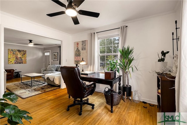 office area featuring ceiling fan, light wood finished floors, ornamental molding, and baseboards