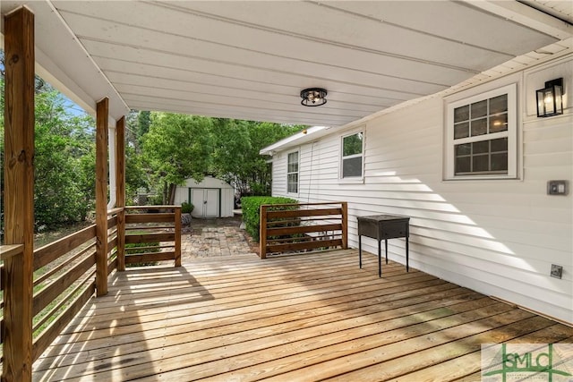 wooden deck with a storage unit and an outdoor structure