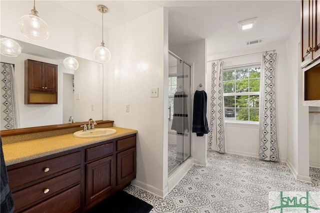 full bath with a stall shower, baseboards, and vanity