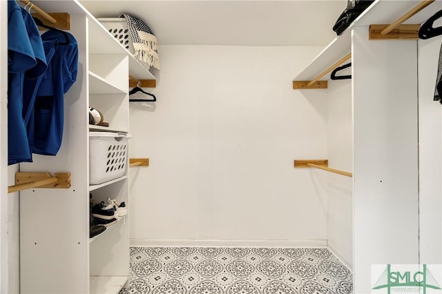walk in closet with light floors