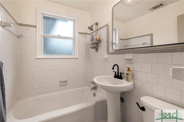 full bath featuring tile walls, shower / bathtub combination, and toilet