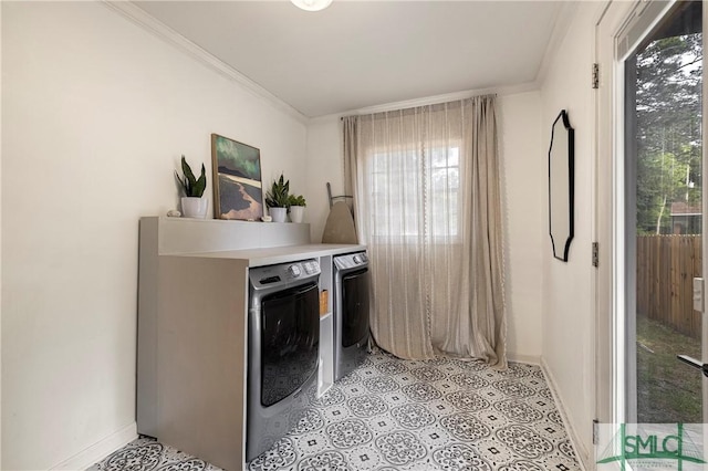 laundry room featuring washing machine and clothes dryer, plenty of natural light, baseboards, and crown molding