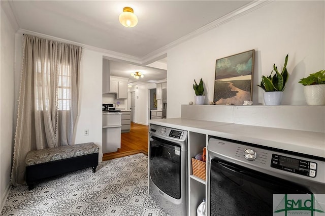 kitchen featuring ornamental molding, washer and dryer, light countertops, light wood-style flooring, and white cabinetry