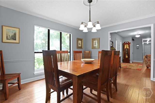 6 Ramsgate Rd, Savannah, GA 31419 - dining space with light wood-type flooring, a chandelier, baseboards, a textured ceiling, and ornamental molding