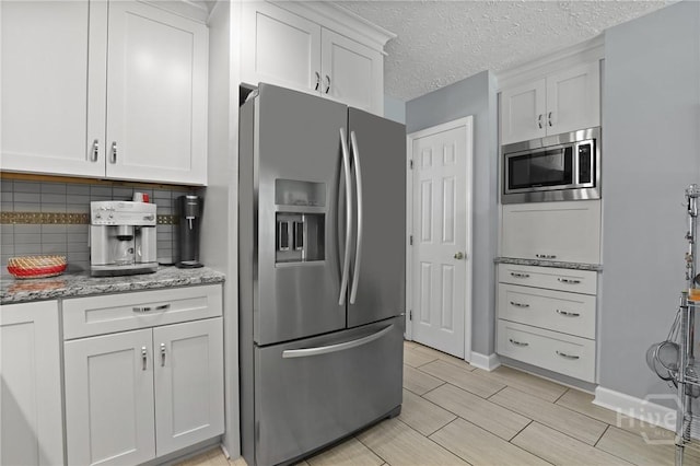 6 Ramsgate Rd, Savannah, GA 31419 - kitchen with appliances with stainless steel finishes, tasteful backsplash, white cabinetry, light stone counters, and a textured ceiling