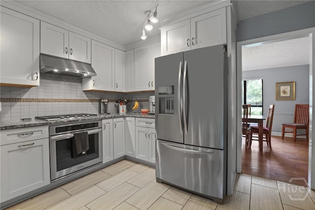 6 Ramsgate Rd, Savannah, GA 31419 - kitchen featuring appliances with stainless steel finishes, under cabinet range hood, backsplash, a textured ceiling, and light stone counters