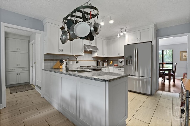 6 Ramsgate Rd, Savannah, GA 31419 - kitchen featuring stainless steel refrigerator with ice dispenser, under cabinet range hood, a sink, stone countertops, and a textured ceiling
