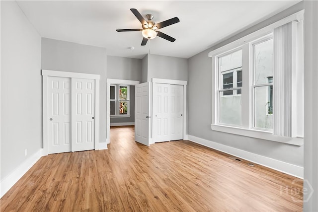 523 E 39th St, Savannah, GA 31401 - unfurnished bedroom featuring two closets, baseboards, light wood finished floors, and ceiling fan
