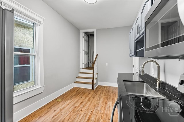 523 E 39th St, Savannah, GA 31401 - kitchen with stainless steel microwave, light wood-type flooring, baseboards, black range with electric stovetop, and dark countertops