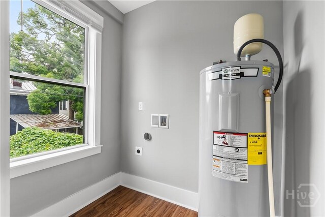 523 E 39th St, Savannah, GA 31401 - laundry area with water heater, electric dryer hookup, dark wood-type flooring, baseboards, and washer hookup