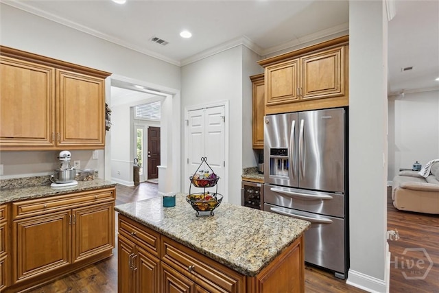 kitchen featuring stainless steel refrigerator with ice dispenser, dark wood-style flooring, light stone counters, crown molding, and a kitchen island