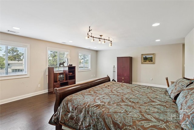 bedroom with multiple windows, wood finished floors, baseboards, and recessed lighting