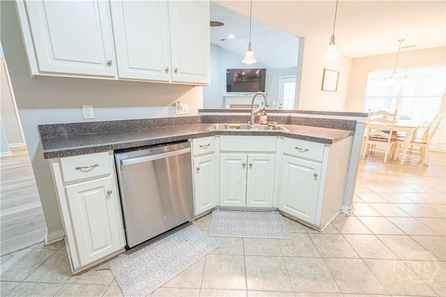 kitchen with stainless steel dishwasher, a sink, dark countertops, and white cabinets