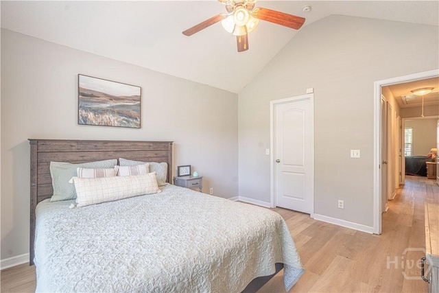 bedroom with attic access, light wood finished floors, high vaulted ceiling, baseboards, and a ceiling fan